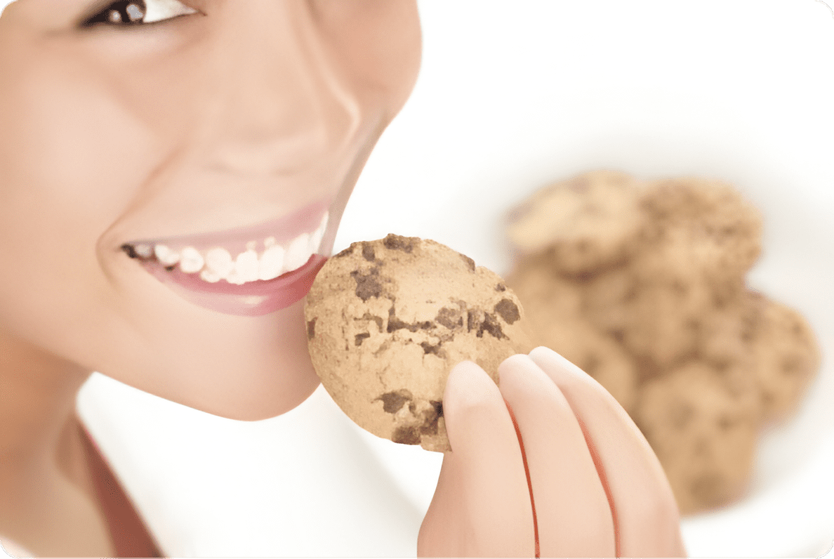 A woman holding onto some cookies with both hands.