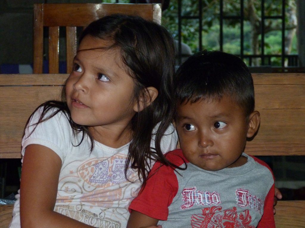 A little girl and boy sitting next to each other.