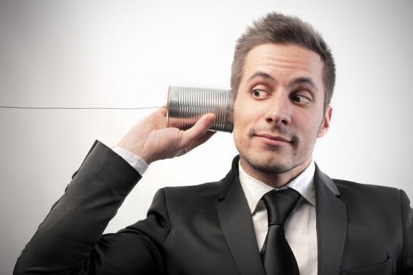 A man in a suit holding onto a tin can