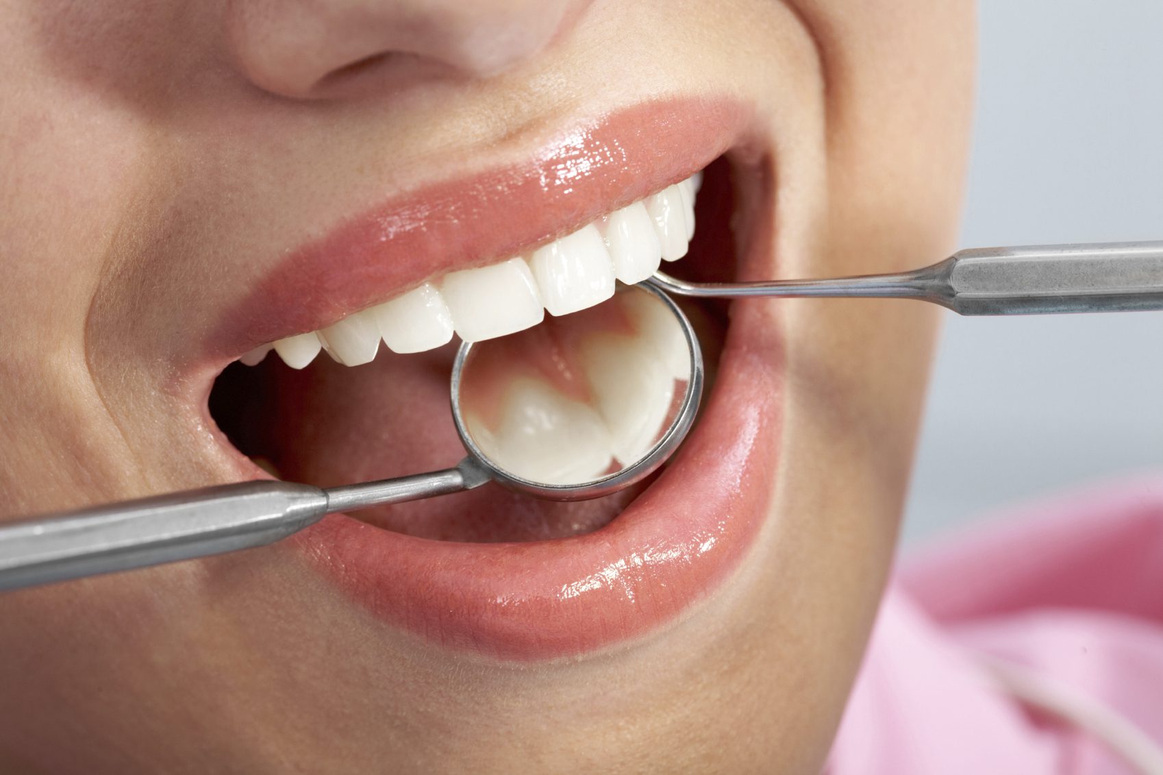 A woman is holding a spoon in her mouth.