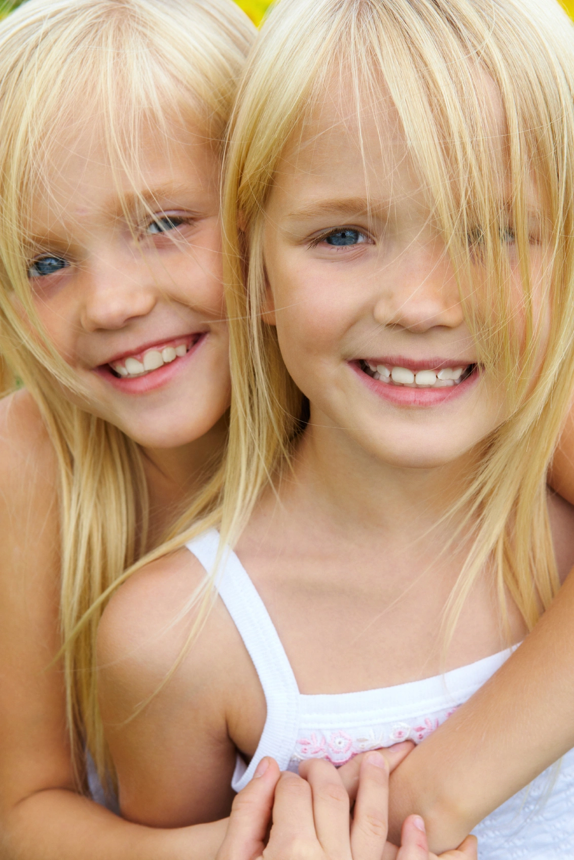 Two young girls posing for a picture.