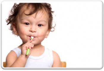 A young child is brushing his teeth with an electric toothbrush.