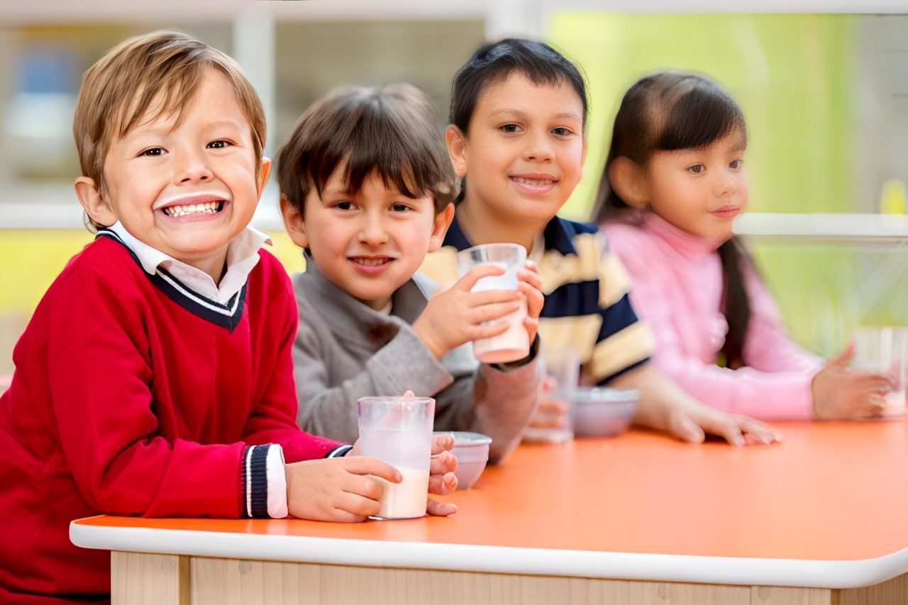 A group of children sitting at a table with drinks.