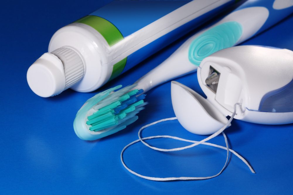 A close up of two electric toothbrushes and an electronic device